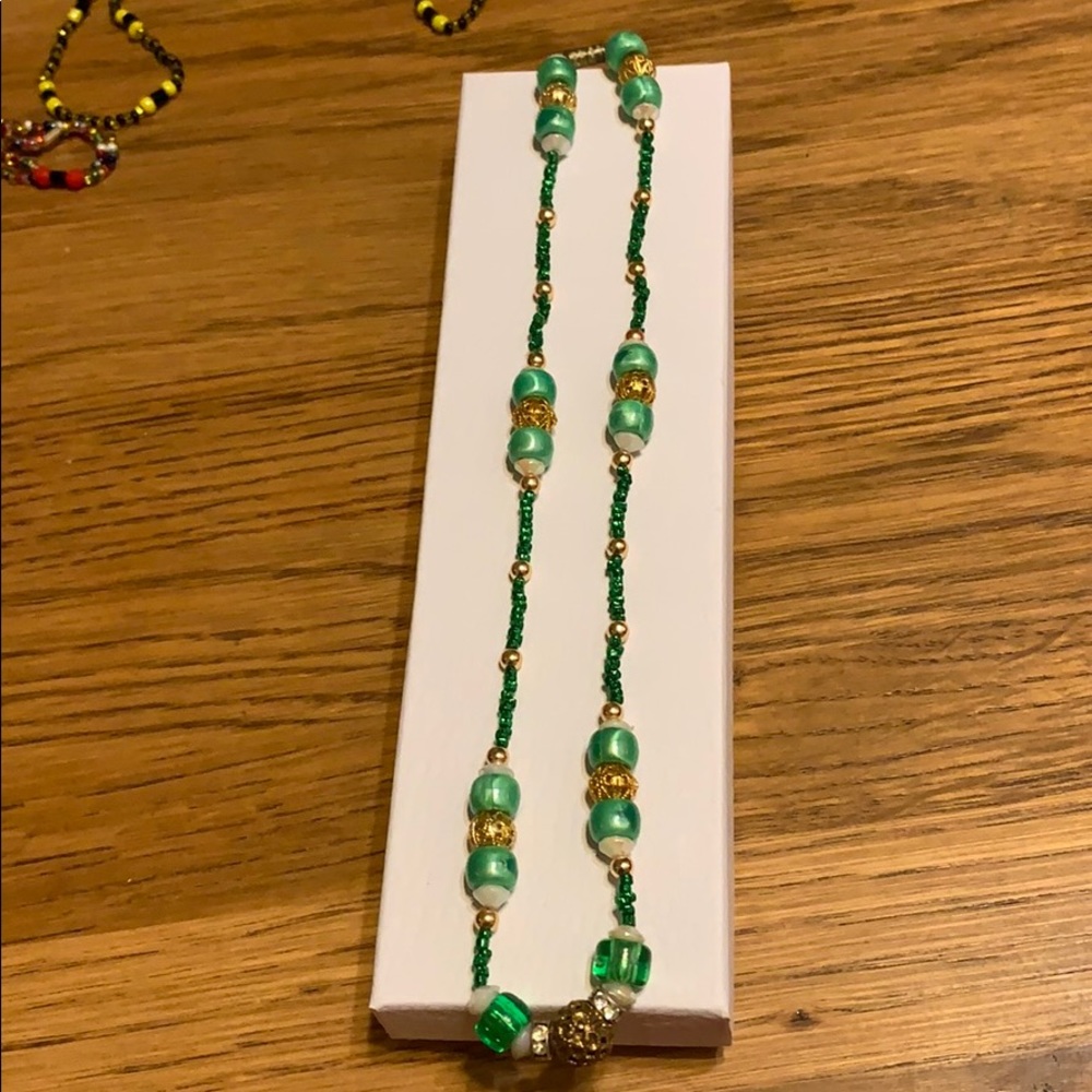 Necklace with shades of green & gold beads.